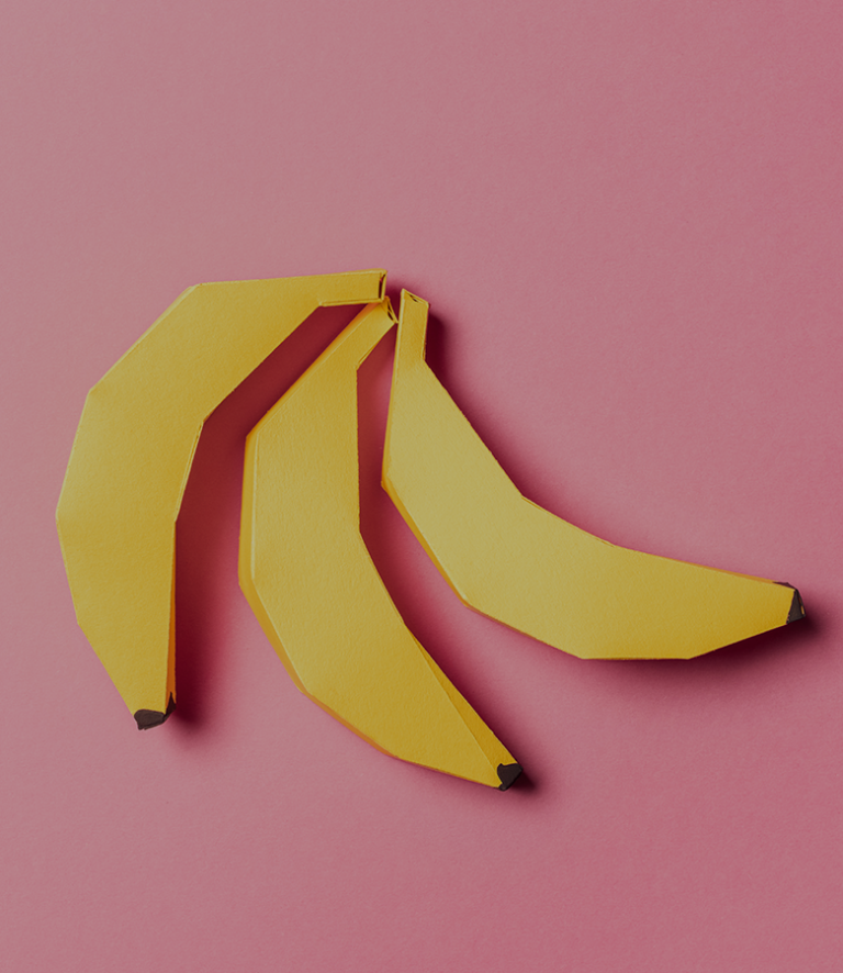 Image of cardboard cut out bananas on pink background.